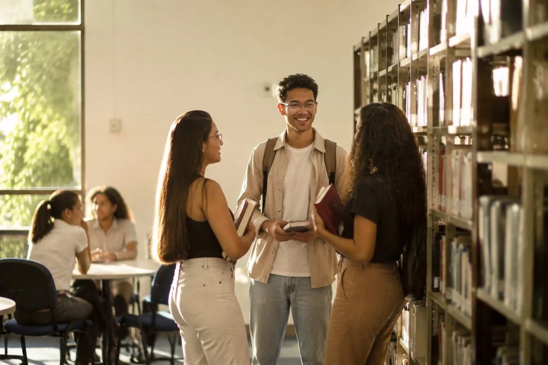 Pessoas numa sala de reunião clara, uma delas de pé explicando um ponto